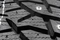 Macro shot winter studded tire. Winter car tires texture. Tyre protector close up. Square powerful spikes. Black studdable winter