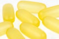 Macro shot of yellow gelatin capsules, isolated on a white background. Royalty Free Stock Photo