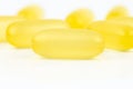 Macro shot of yellow gelatin capsules, isolated on a white background. Royalty Free Stock Photo