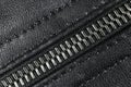 Macro shot of zipper on black leather texture background with stitching. Horizontal background from a close-up of black leather ma