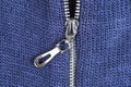 Macro shot of zipper on blue wool texture background with stitching. Horizontal background from a close-up of wool material