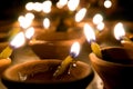 Macro shots of diyas being lit by hand or candle for the hindu religious festival of Diwali.