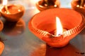 Macro shots of diyas being lit by hand or candle for the hindu religious festival of Diwali.