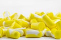 Macro shots of multiple earplugs in yellow and white for noise protection, isolated on white background. Royalty Free Stock Photo