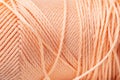 Macro texture of bright coral silk thread, close-up, copy space. Macro Photography of a coil with threads. Sewing
