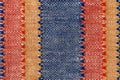 Macro texture of plain weave fabric. Striped cloth background of red, blue, orange and white colors. Textile canvas surface close- Royalty Free Stock Photo