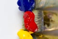 Macro three paint brushes with red, yellow and blue paint on a white background. Place for text, for banner, for site. Royalty Free Stock Photo