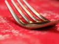 Macro of the tines of a fork with red tablecloth Royalty Free Stock Photo