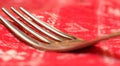 Macro of the tines of a fork with red tablecloth Royalty Free Stock Photo