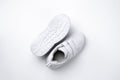 macro top view Two white unisex running shoes, one running shoe lies sole up on white background