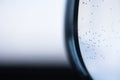 Macro of transparent wine glass with water with small bubbles. Blue black white blurred.