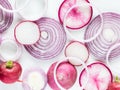 A macro view of an arrangement of overlapping red onion rings and daikon, radish and red onion slices.