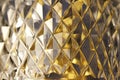 Macro view of beautiful lead crystal glass with diamond cut facets reflecting golden color Royalty Free Stock Photo