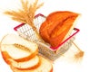 Macro view of bread, bun, sliced loaf, baguette and ears in metal shopping basket. On white background