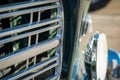 Macro view of chrome grill and headlamp on classic automobile Royalty Free Stock Photo