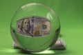 Macro view of crystal ball with 100 dollar bill isolated on green background. Royalty Free Stock Photo