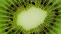 Macro view of kiwi slice rotation. Extreme closeup of green juicy texture with seeds of exotic fruit. Concept of healthy Royalty Free Stock Photo