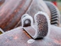 Macro view of a piece of metal on top of the metal casing of the motor of a concrete mixer completely frozen