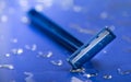 Macro view of safety razor blade on water drops background