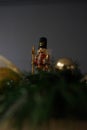 Macro view of a small figurine of a nutcracker in the background of Christmas decorations Royalty Free Stock Photo