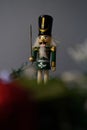 Macro view of a small figurine of a nutcracker in the background of Christmas decorations Royalty Free Stock Photo