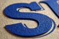 A macro view of a textured surface, showcasing a deep blue letter with tactile paper, emphasizing detail and precision printing Royalty Free Stock Photo