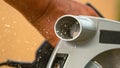 MACRO: Wood chippings fly away from a rotating saw blade cutting into plywood.