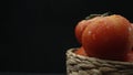 Macrography, tomatoes nestled within basket with black background. Comestible. Royalty Free Stock Photo