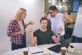 Mad and angry young man and woman wave with hands. They look at guy whi meditates. He keep hands aside and eyes closed. Royalty Free Stock Photo