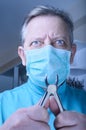 Mad dentist with pliers in his hands