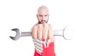 Mad and evil mechanic holding a big wrench Royalty Free Stock Photo