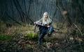 Woman warrior with a sword in her hands, in the woods