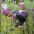 Mad male botanist making photos for his wild grass collection