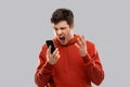 Mad man in red hoodie screaming to smartphone Royalty Free Stock Photo