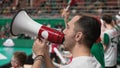 Mad man shout megaphone sport stadium usa. Furious fan screaming bullhorn arena. Royalty Free Stock Photo