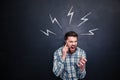 Mad man using cell phone and screaming over blackboard background Royalty Free Stock Photo