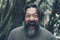 Mad mature man shouting crazy at the camera. Stressed people portrait concept life. Bearded young senior man shout with craziness