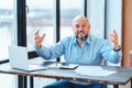 Angry nervous mature businessman yelling and gesticulating with hands in office