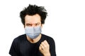 Mad young man wearing a protective face mask prevent virus infection or pollution with fist on white isolated background Royalty Free Stock Photo