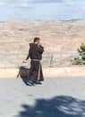 Catholic monk speaks on his mobile phone and walks on the terrace in the courtyard of Memorial Church of Moses on Mount Nebo near