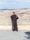 Catholic monk talking on a mobile phone and standing on the terrace in the courtyard of Memorial Church of Moses on Mount Nebo nea