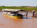 Madagascar cargo boat on river, boys unloading bags