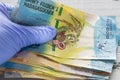 Madagascar money, Ariary banknotes kept in rubber gloves. The concept of economy and financial threats during the Coronavirus pand