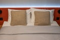 Made bed and brown pillow. close-up of a made-up bed in a hotel room. Clean bedclothes, pillows, bed sheet and blanket in a room. Royalty Free Stock Photo