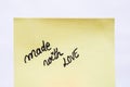 Made with love handwriting text close up isolated on yellow paper with copy space