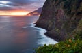 Madeira island - Dramatic sunrise over atlantic ocean with waterfall landscape from Miradouro do Veu da Noiva