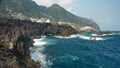 Madeira Island. Picturesque rocky coastline of volcanic lava with frothy surf. Copy space. Royalty Free Stock Photo