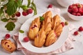 Madeleine cookies with raspberries. Traditional French biscuits in a shape of seashells.