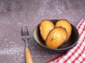 Madeleine homemade traditional French small cookie on a bowl placed on a wooden table.