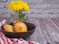 Madeleine homemade traditional French small cookie on a bowl placed on a wooden table with white brick background